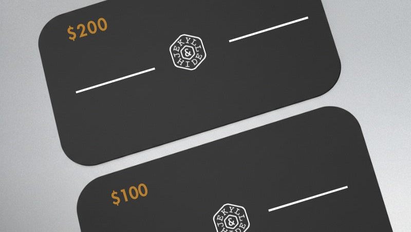 Two black gift cards with gold and white text on a gray background