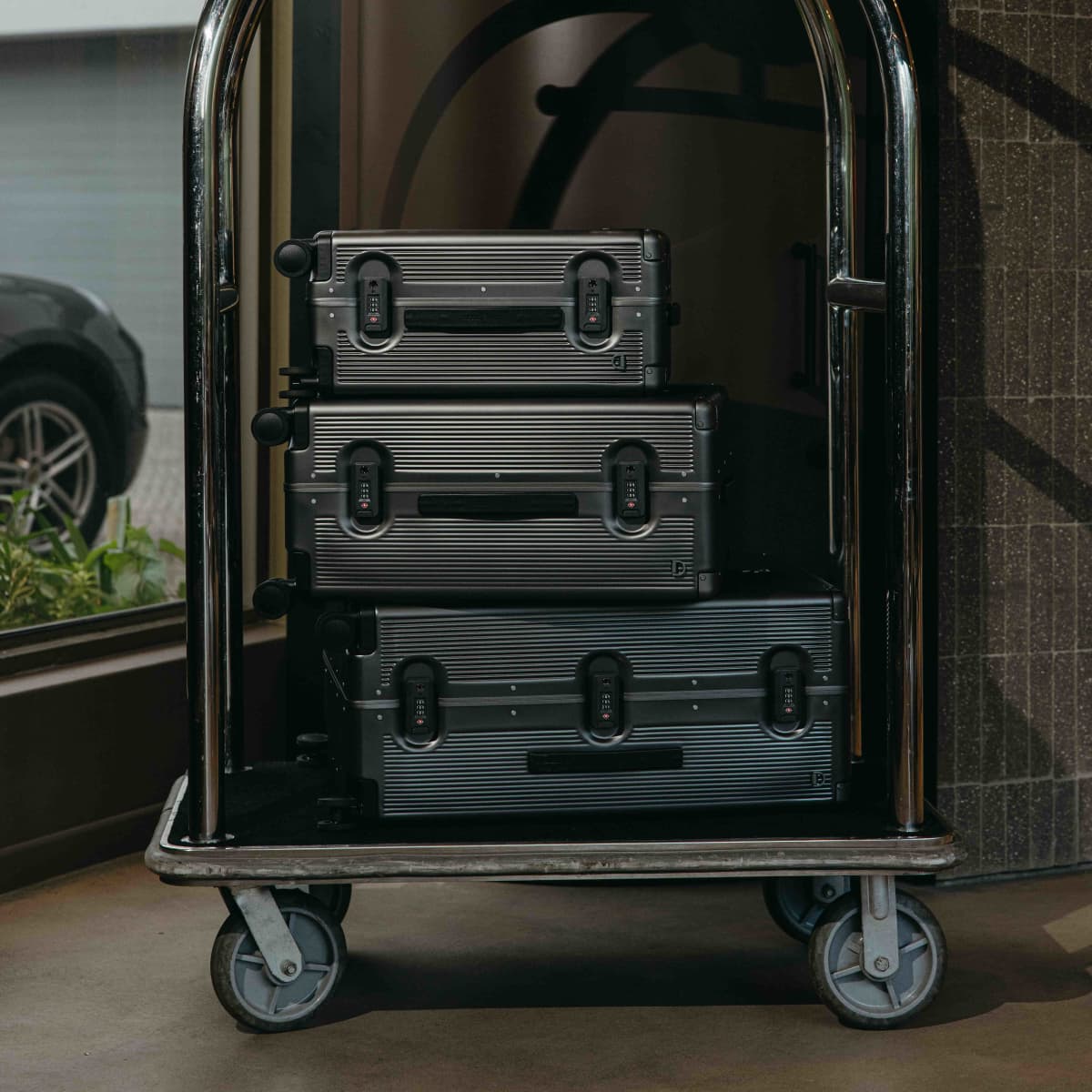 Jekyll & Hide graphite-black Carry-On, Medium Check-In and Large Check-In stacked on a hotel luggage trolley