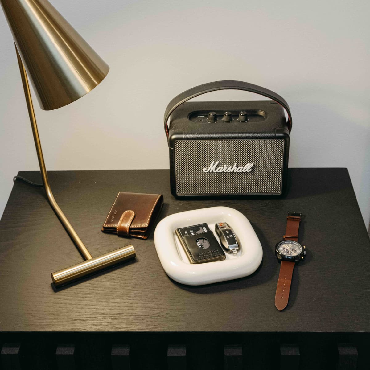 Mocha leather Wallet With Coin on a bedside table with a watch and speaker