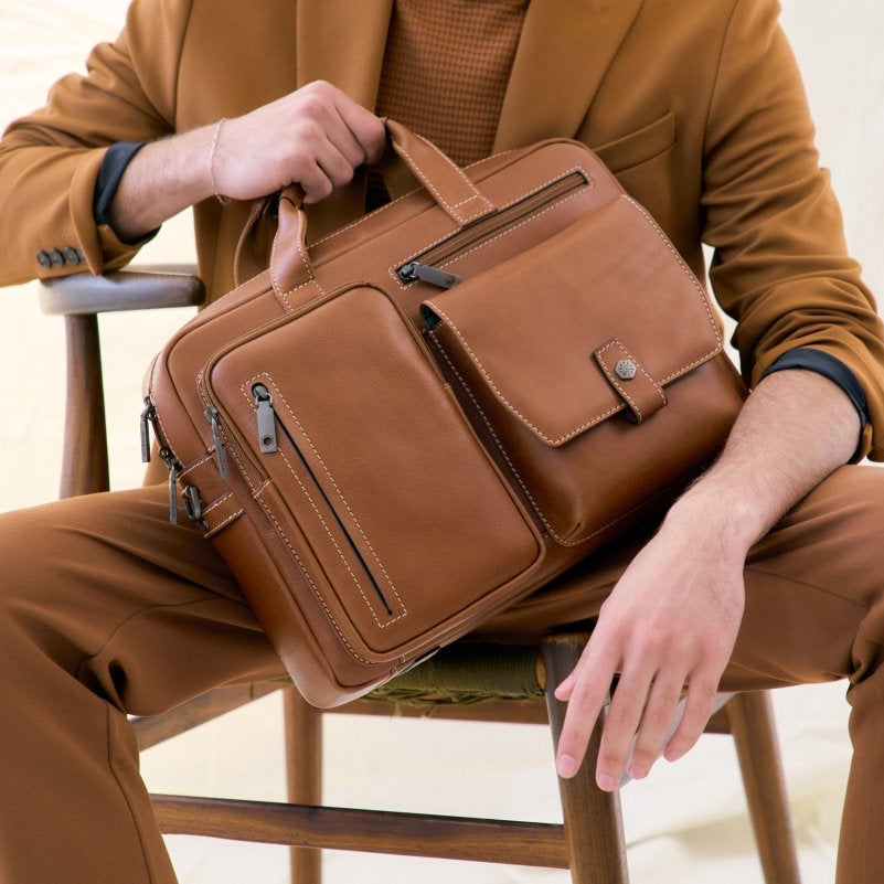 Man in a tan suit seated with the Jekyll & Hide Colt leather Laptop Briefcase on his lap