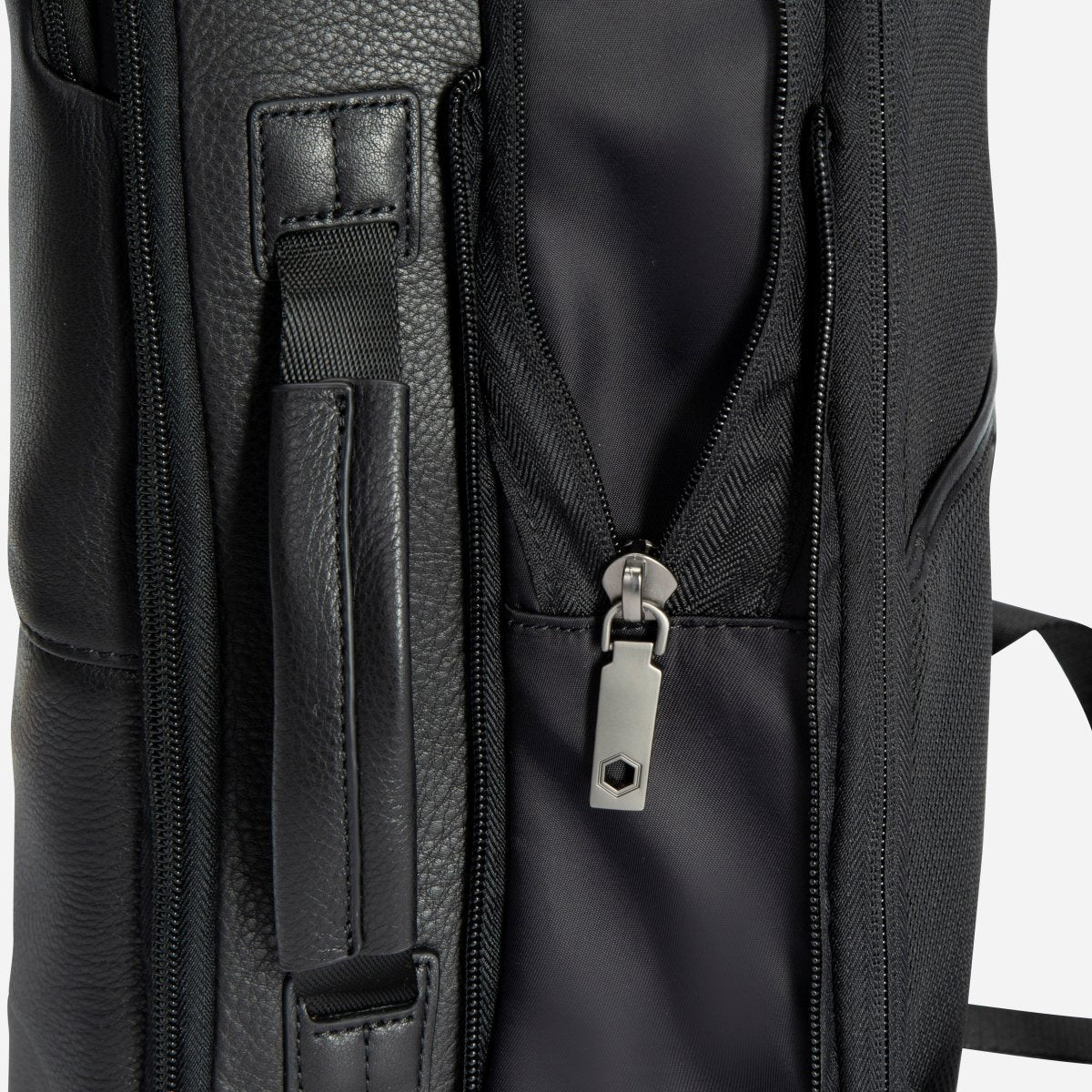 Close-up of the black leather backpack's side carry handle and expander zip – Jekyll & Hide