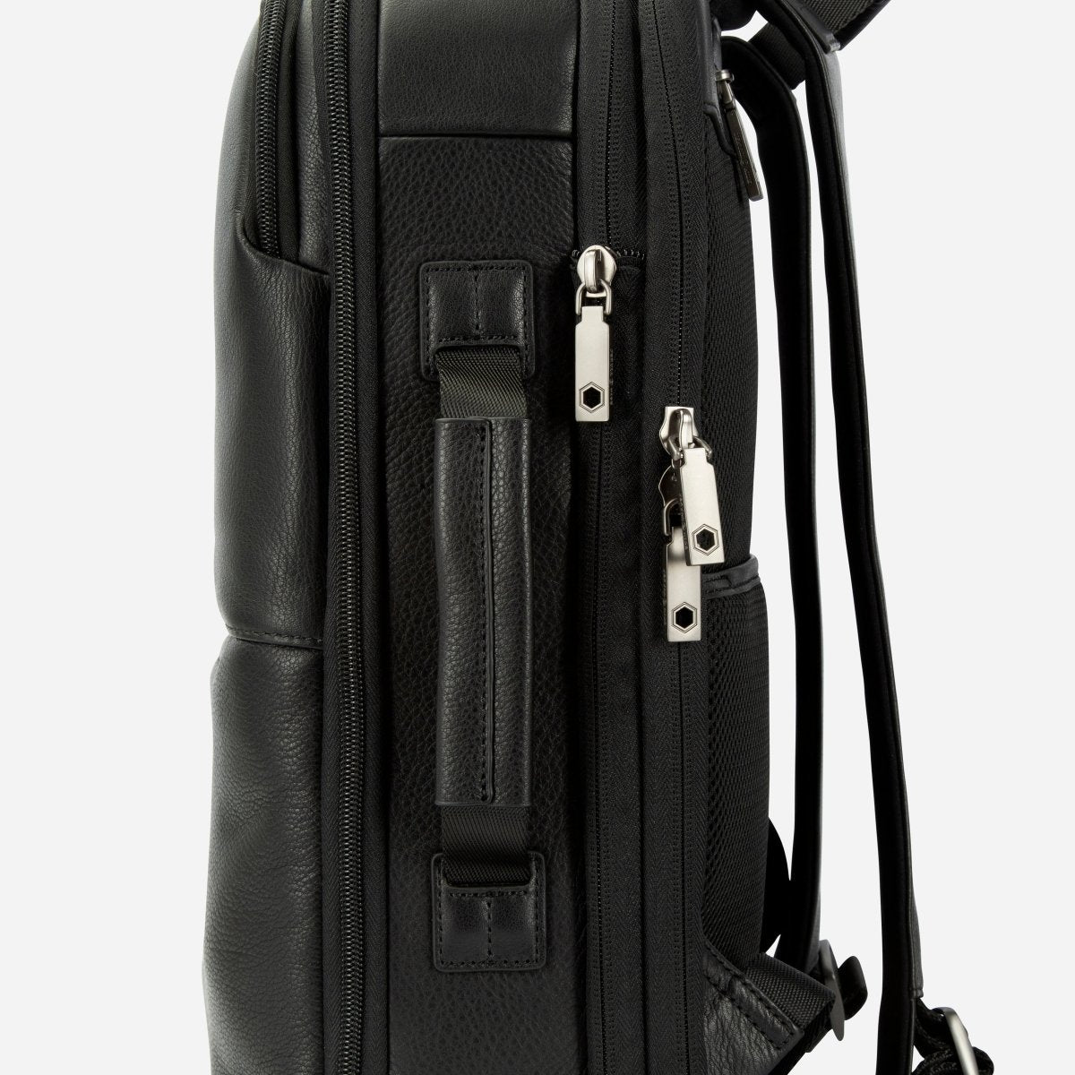 Side view of the black leather backpack showing the carry handle and side zip pockets – Jekyll & Hide