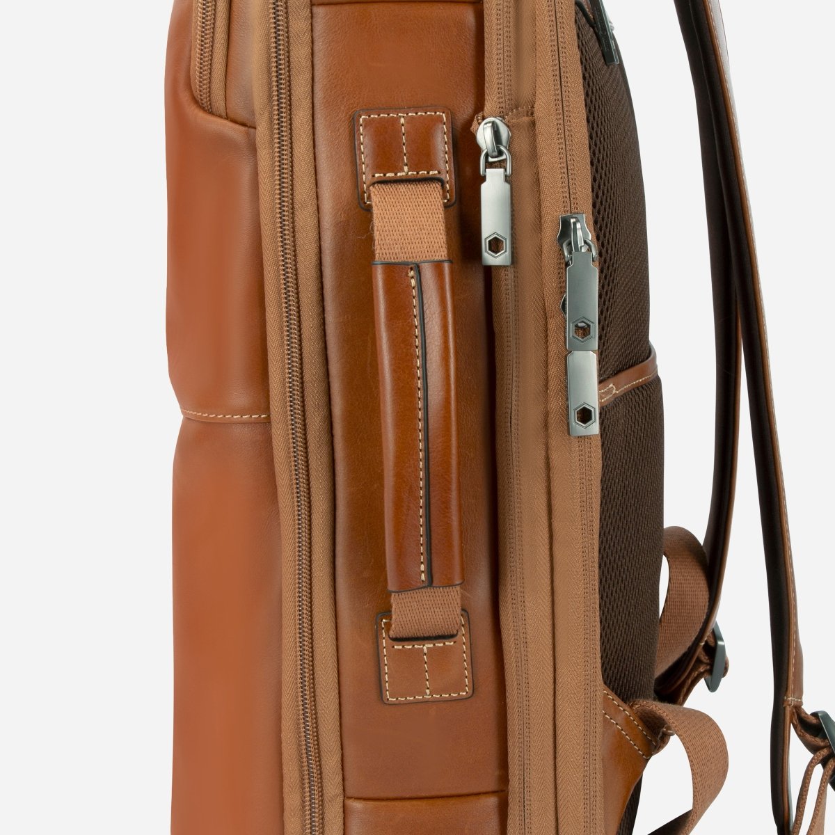 Side view of the tan leather backpack showing the carry handle and side zip pockets – Jekyll & Hide