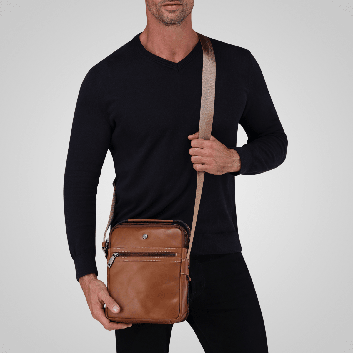 Man in black wearing the Colt tan leather Crossbody Organiser on its shoulder strap