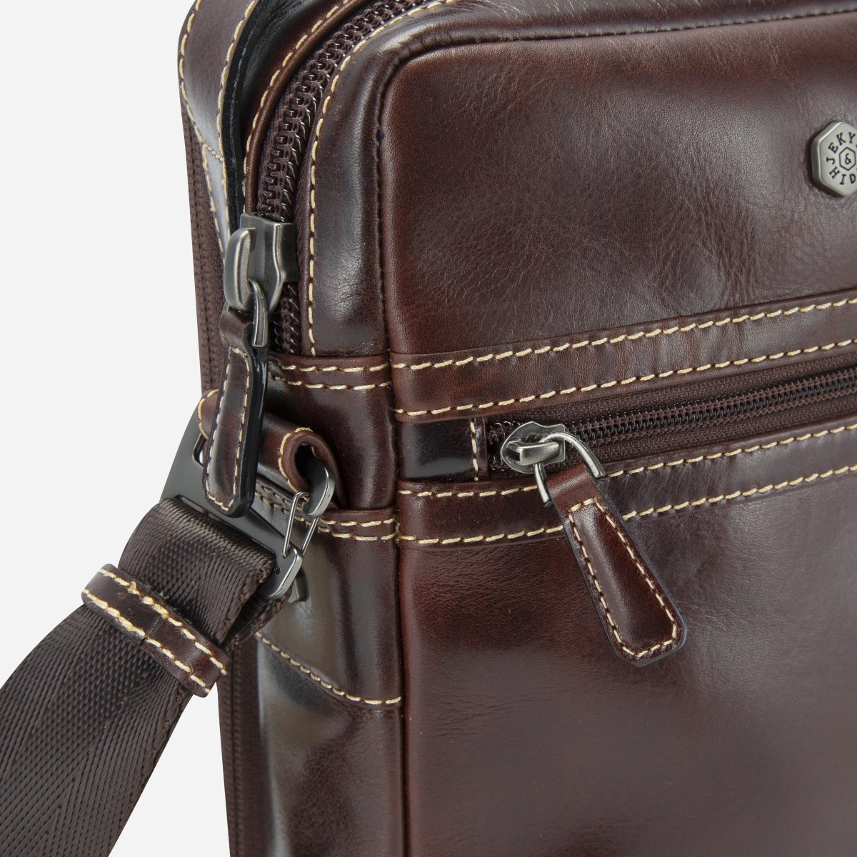 Close-up of the Mocha Crossbody Organiser's twin zips and contrast stitching