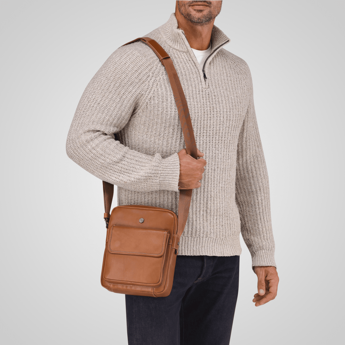 Man in a knit jumper wearing the Colt tan leather Crossbody Organiser