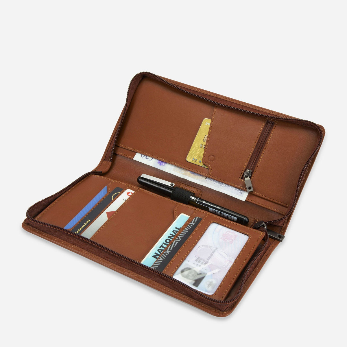 Tan Travel Organiser open with a passport, boarding pass, pens and cards in its pockets