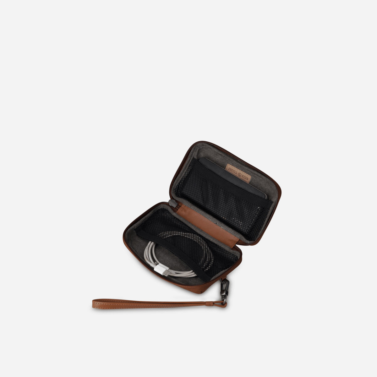 Tan Cable Pouch unzipped with a coiled cable inside and wrist strap attached