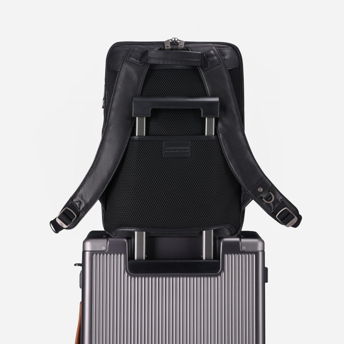 Black leather laptop backpack slipped over a trolley case's telescopic handle – Jekyll & Hide