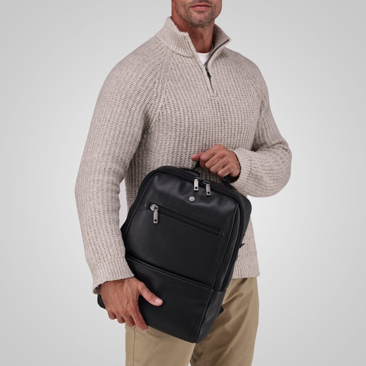 Man holding the black leather laptop backpack by the top handle – Jekyll & Hide