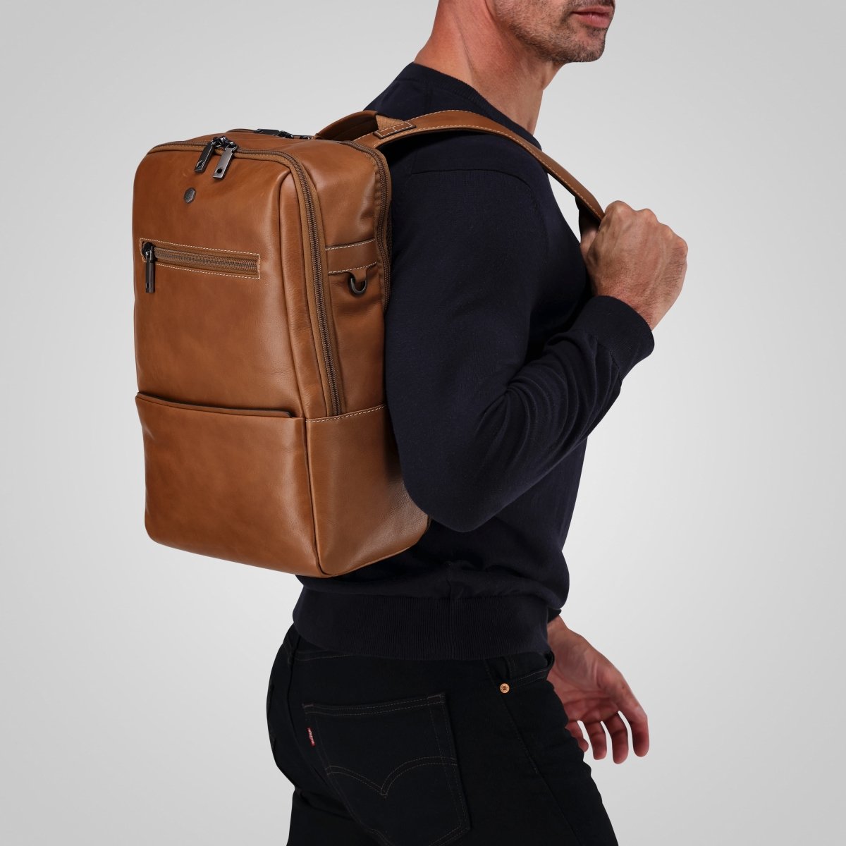 Man carrying the tan leather laptop backpack over one shoulder – Jekyll & Hide