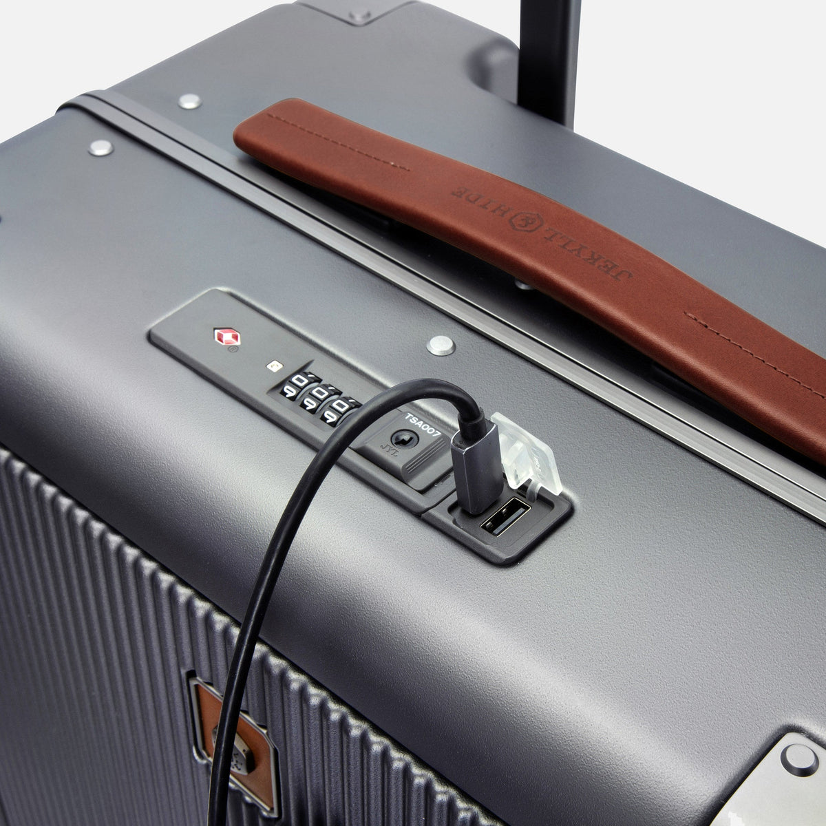 Close-up of the Carry-on's TSA combination lock, USB charging port and Colt leather handle