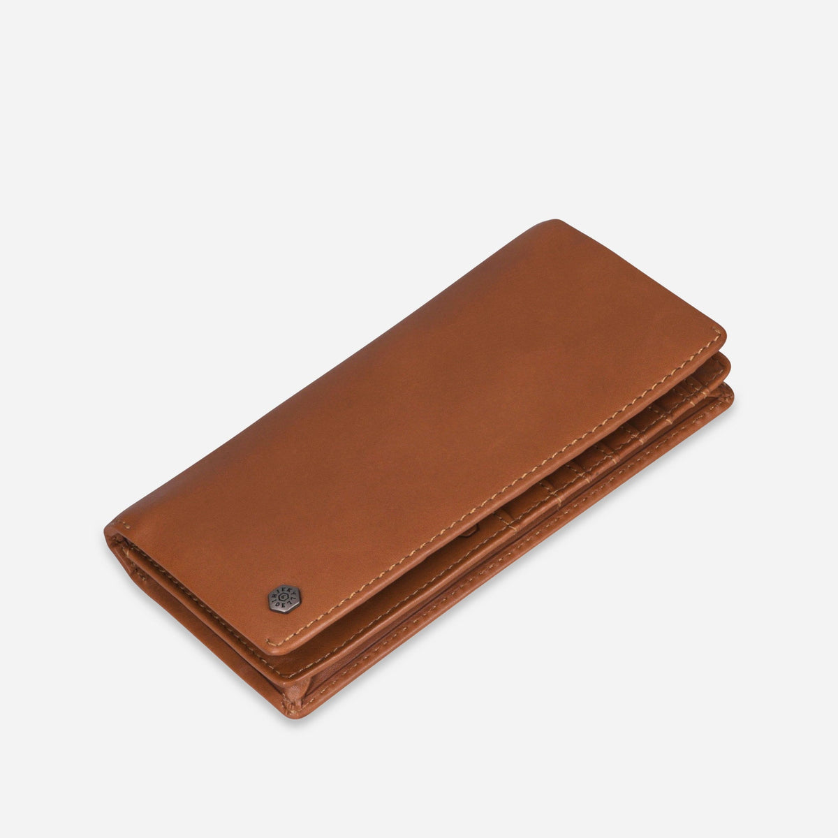 Angled view of the closed tan leather Travel Wallet with logo stud
