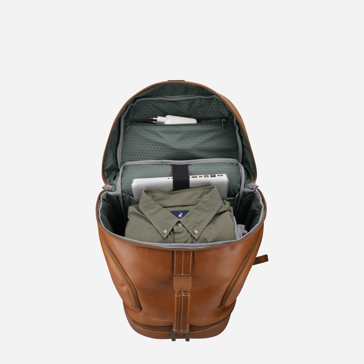 Open tan leather travel backpack showing green lining, laptop and shirt