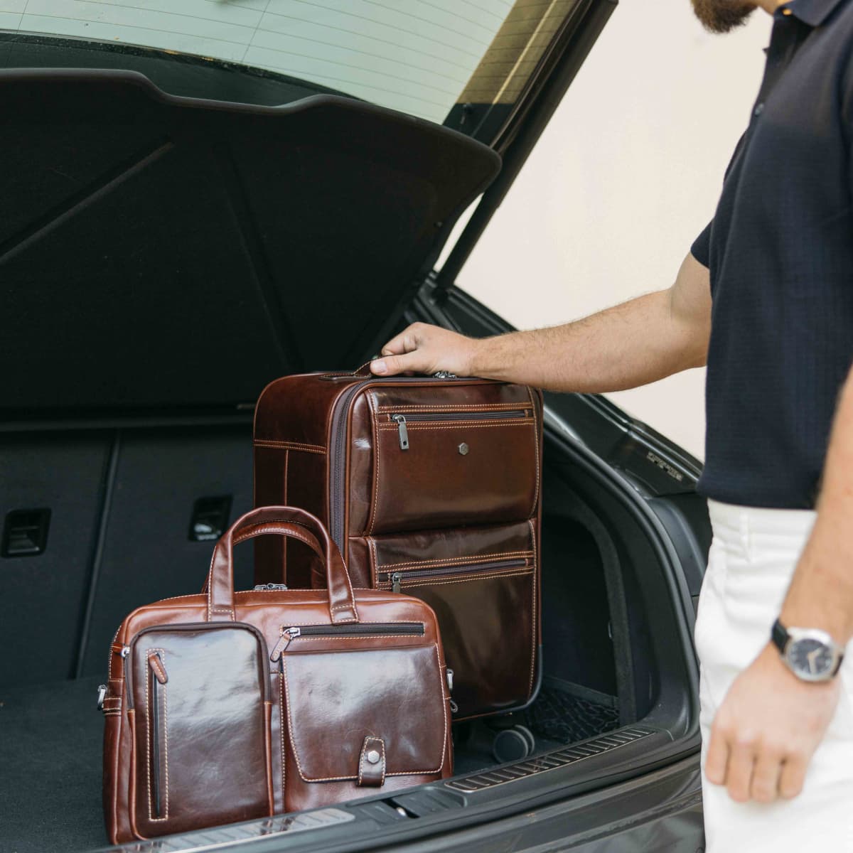 Mocha leather Laptop Briefcase and matching bag being loaded into a car boot