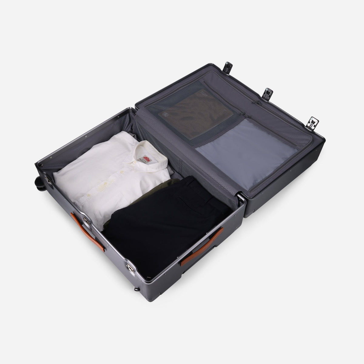 Large Check-In suitcase open and packed with folded shirts, showing the mesh divider