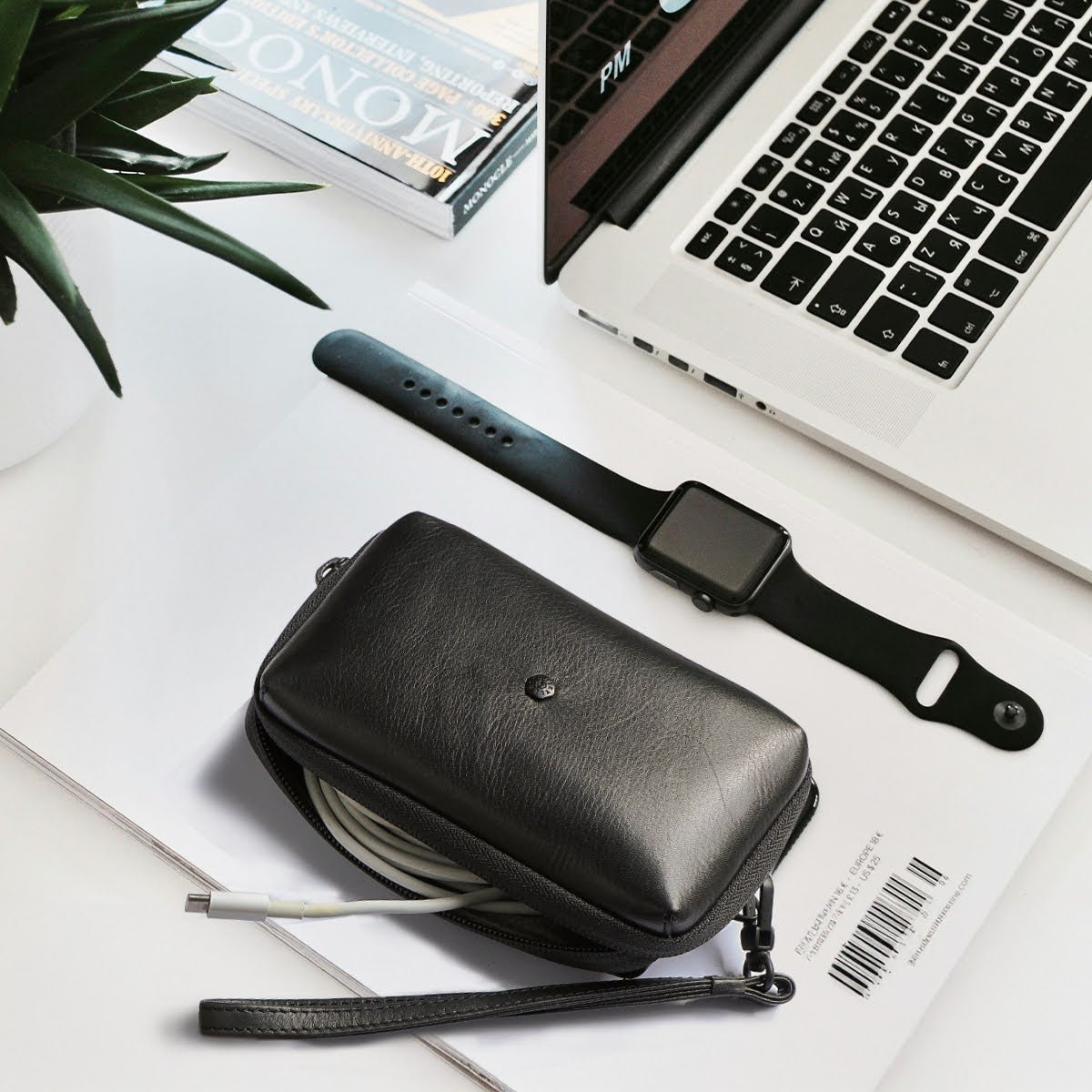 Black leather Cable Pouch on a desk beside a laptop and smartwatch